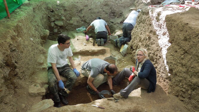 El equipo de arqueólogos e historiadores trabajando en otra fosa de Álora.